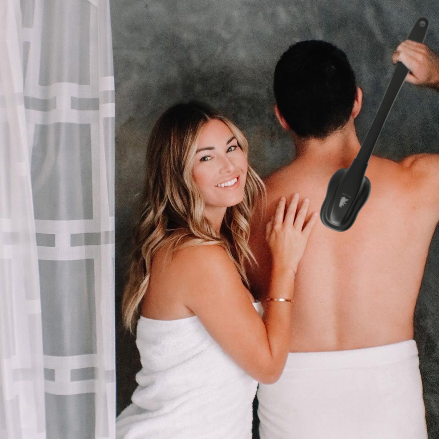 A man and woman relax in a bathtub, with a hairbrush and back scratch tool nearby, enjoying a moment of leisure.