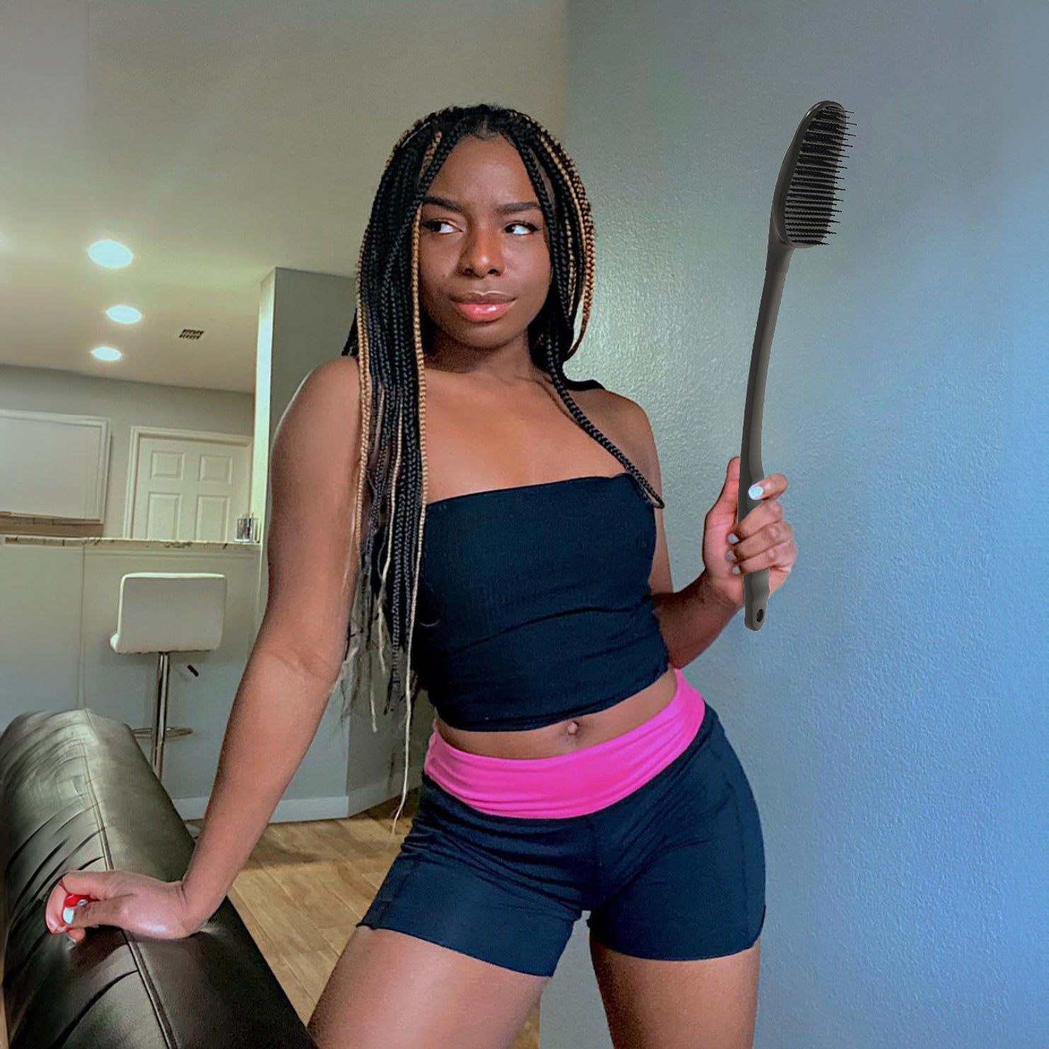 A woman holds a large brush, designed as a back scratch tool, ready to provide relief and comfort.